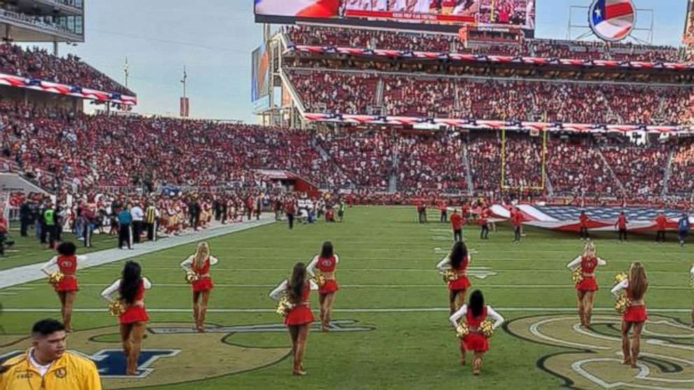 Cheerleader leva um joelho durante o hino nacional